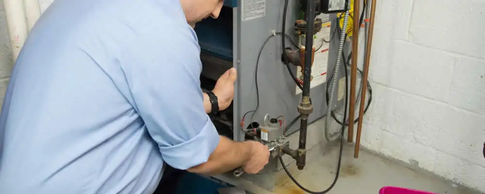 Furnace repair technician inspecting and servicing a home heating system in San Jose, CA
