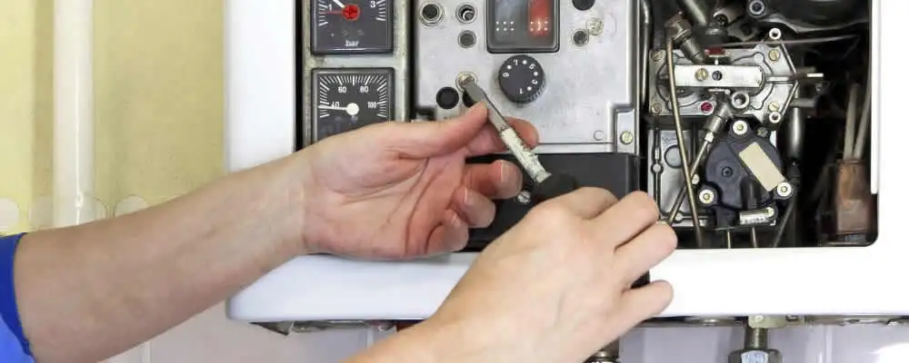 Heating repair technician adjusting boiler controls and components in San Jose, CA