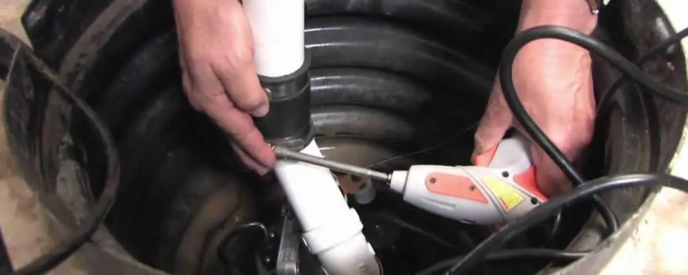 Sump pump installation technician connecting PVC discharge piping in San Jose, CA
