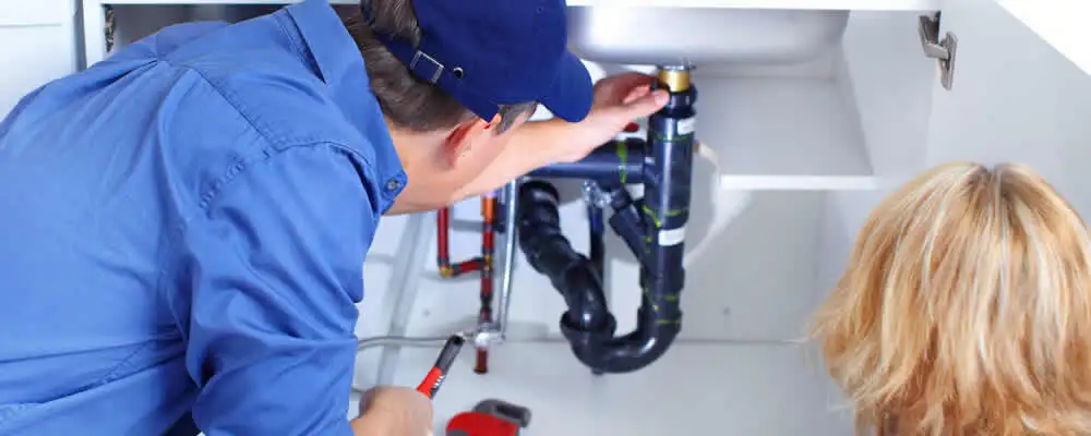 Plumber repairing under-sink drain pipes and fittings in San Jose, CA